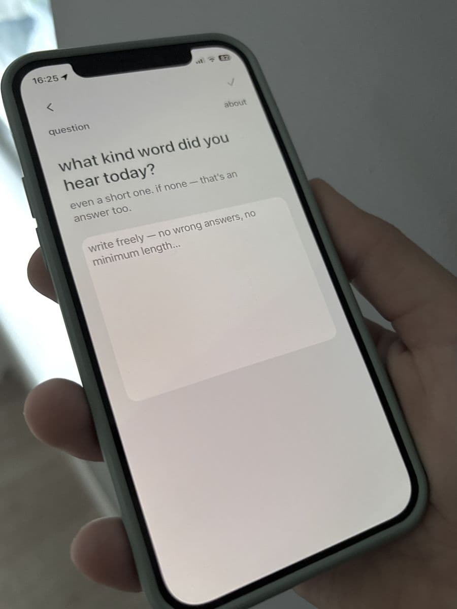 A hand holding a phone with the calmflect question: what kind word did you hear today?